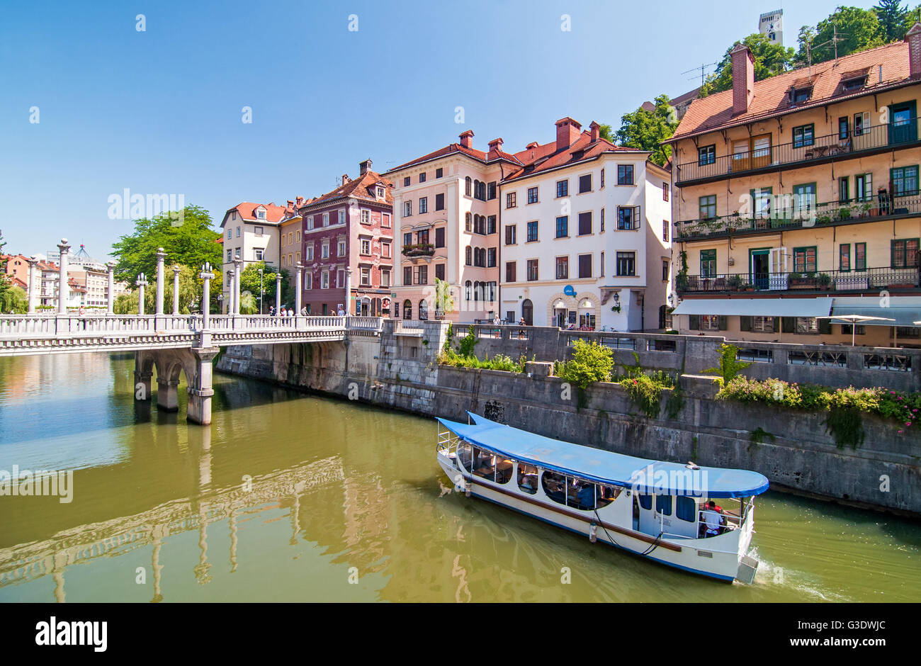 Ljubljana, Slovenia - June 7, 2016 Boat on Ljubljanica river and Cobblers bridge in the background Stock Photo