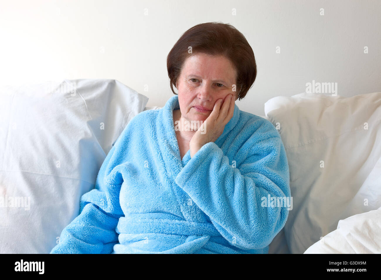 Senior woman in bed with toothache Stock Photo