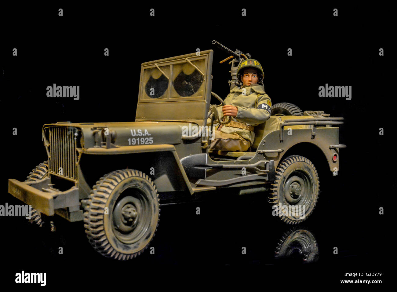 G.I. Joe Action Man doll wears U.S. Army military police MP uniform while sitting in Jeep reenacting post D-Day 1944, in black background studio Stock Photo