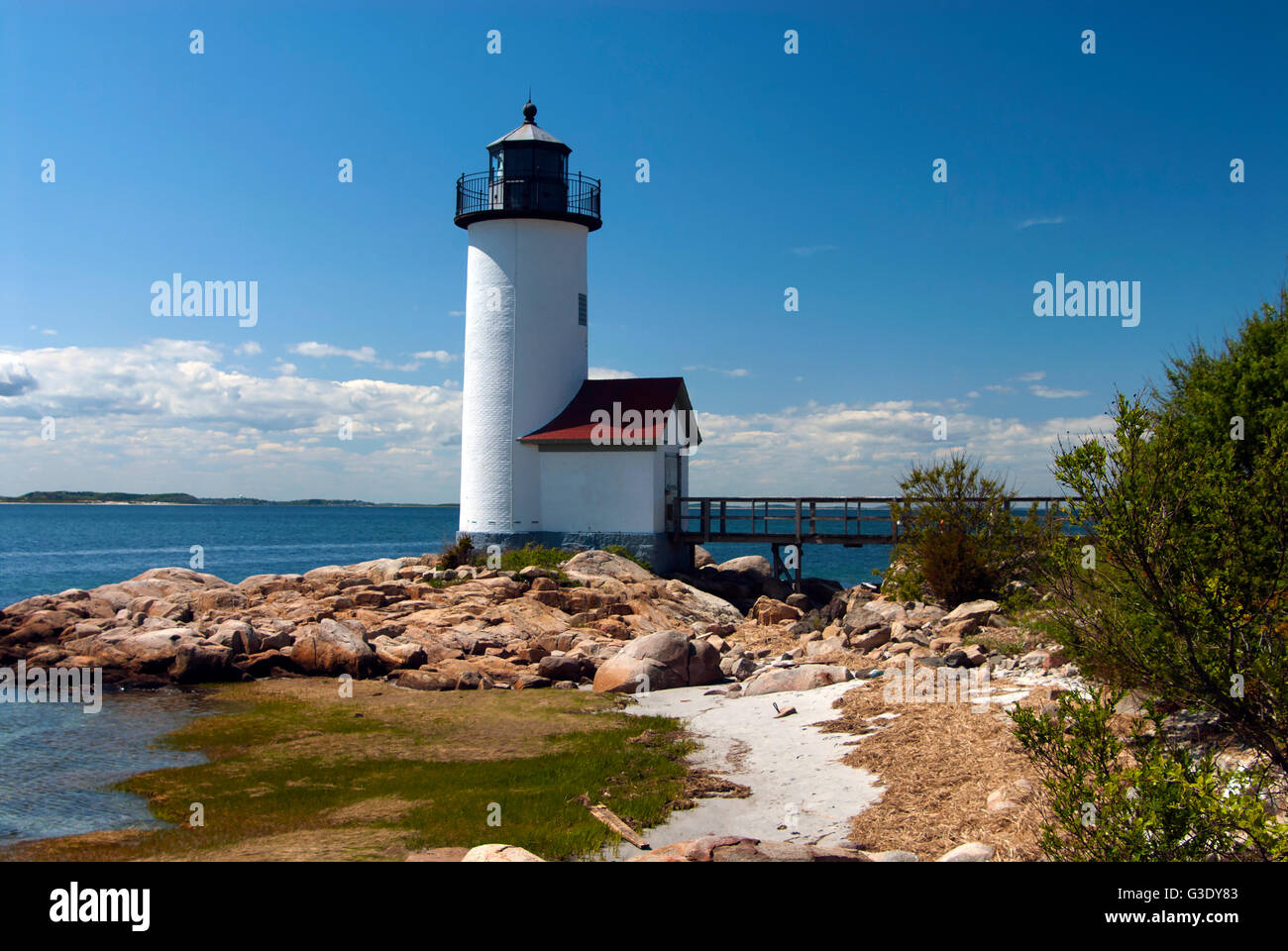 Annisquam lighthouse overlooks harbor along rocky coast in Massachusetts. Stock Photo