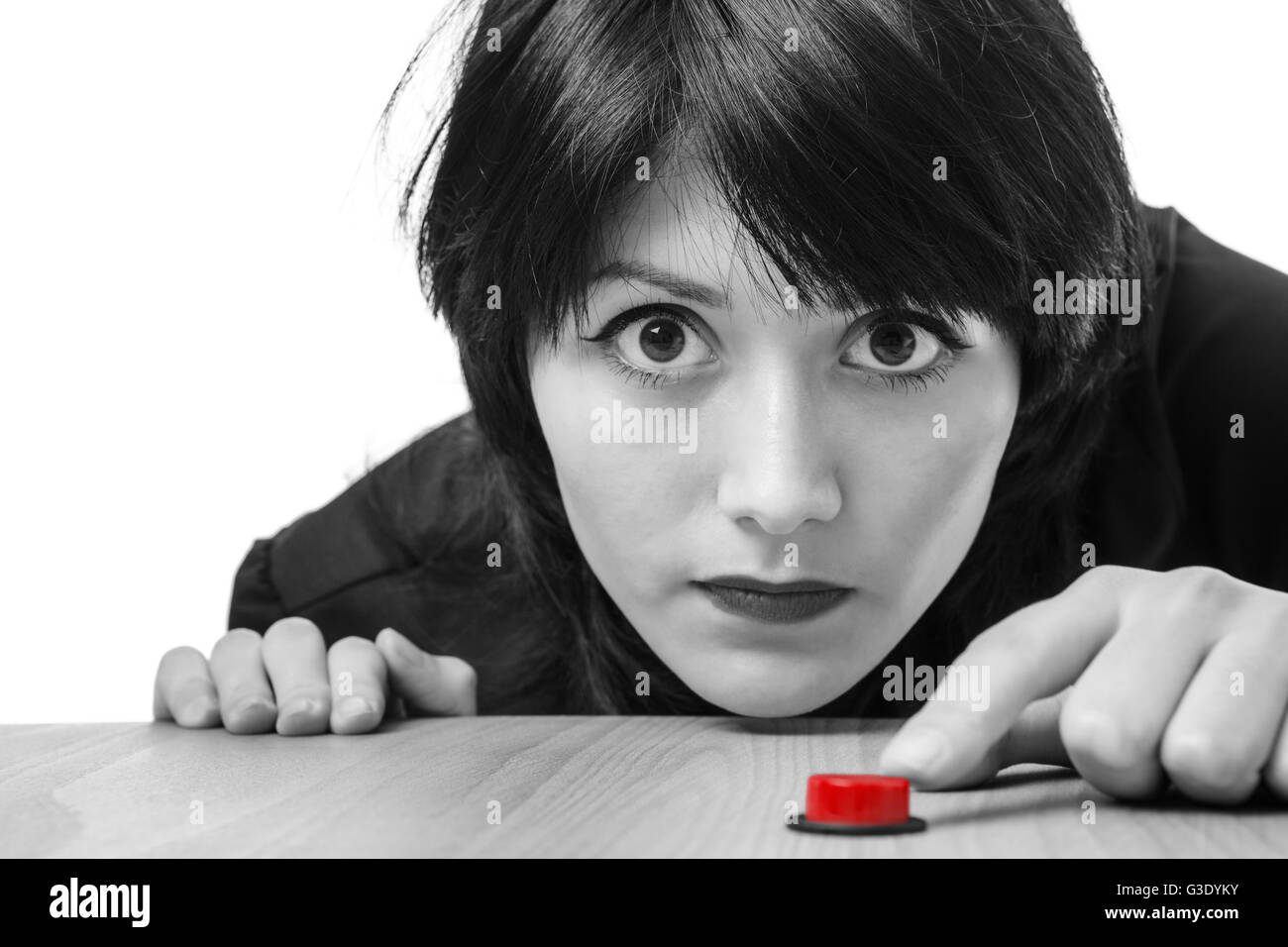 Close up studio shot of a young business model wearing a black blouse, ready to press a red button.  Isolated on white. Stock Photo