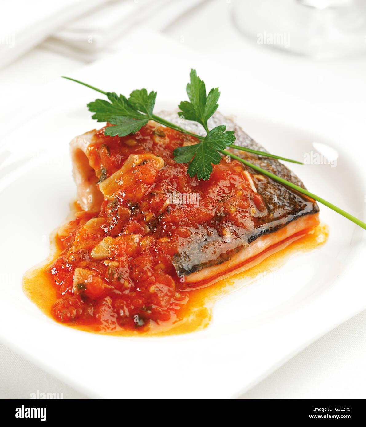 Fried trout fillet with a tomato, onion and garlic sauce. Stock Photo