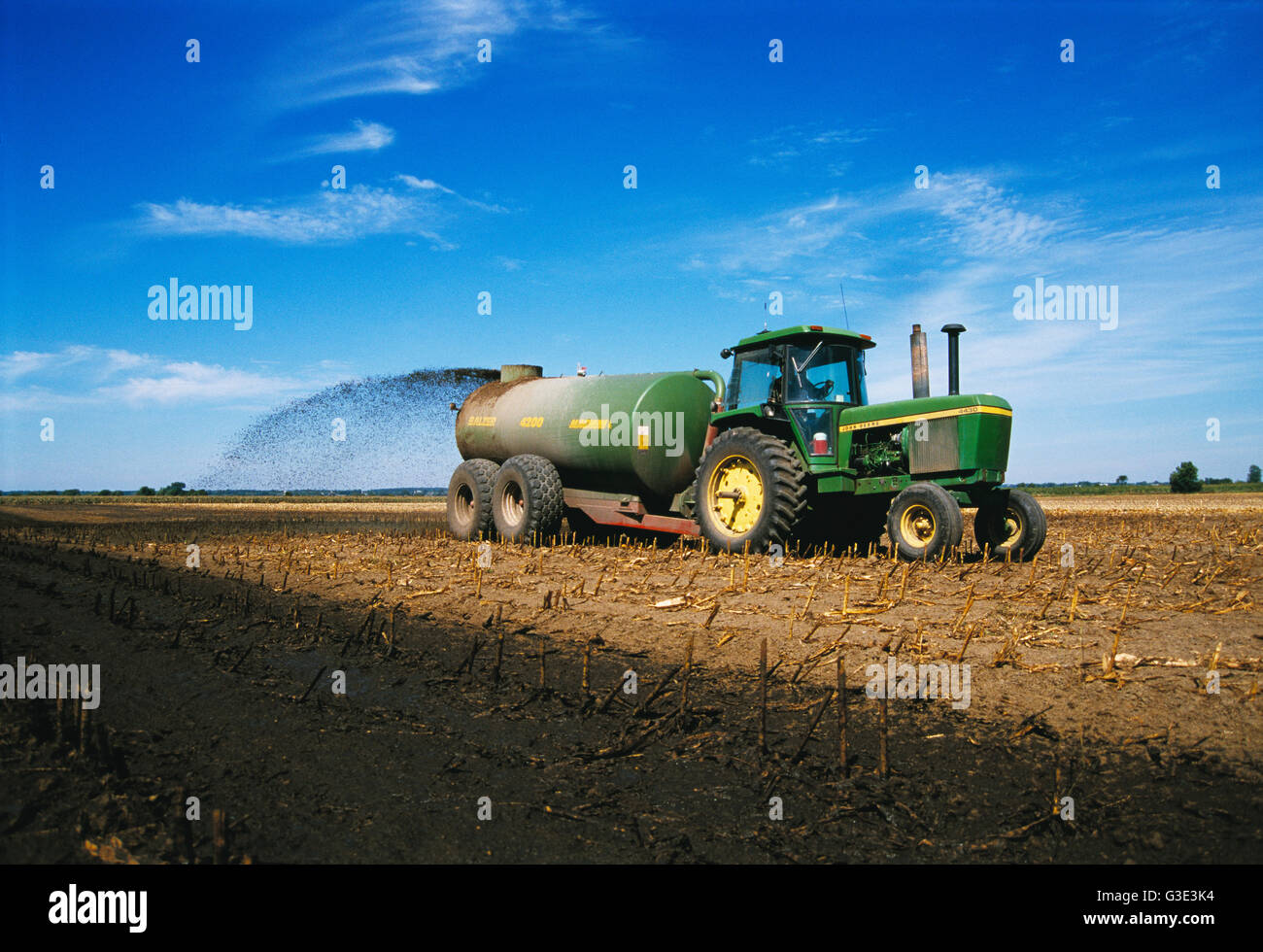 Agriculture A tractor and tank spreader spread liquid manure on a