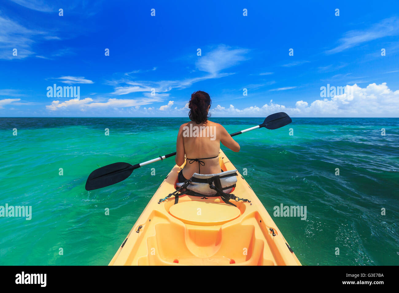 A woman in a bikini in a kayak on the Caribbean, Saint Georges Caye Resort; Belize City, Belize Stock Photo