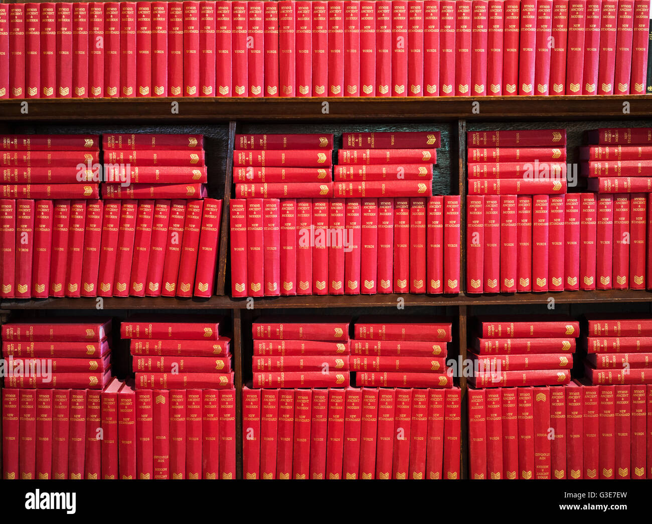 Abundance of red books on a shelving unit; Yorkshire Dales, England Stock Photo