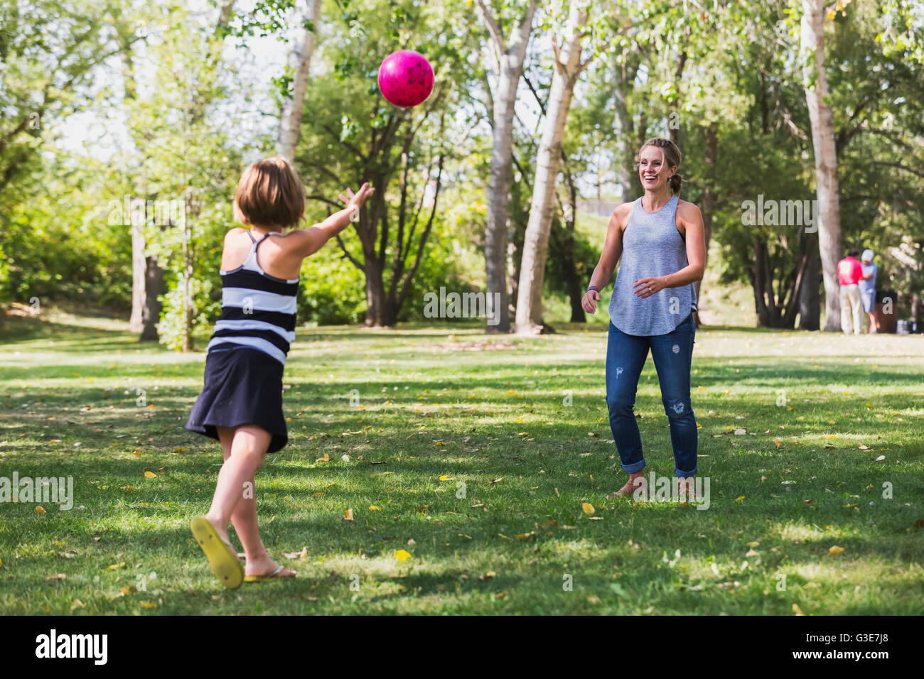 Mother and daughter throwing a ball in a park during a family outing; Edmonton, Alberta, Canada Stock Photo