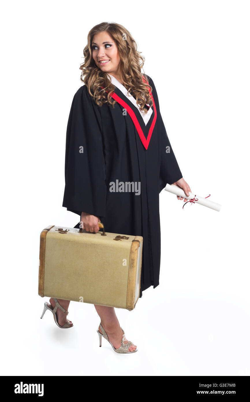 Young graduating woman holding luggage symbolizing that she is now leaving home; Edmonton, Alberta, Canada Stock Photo