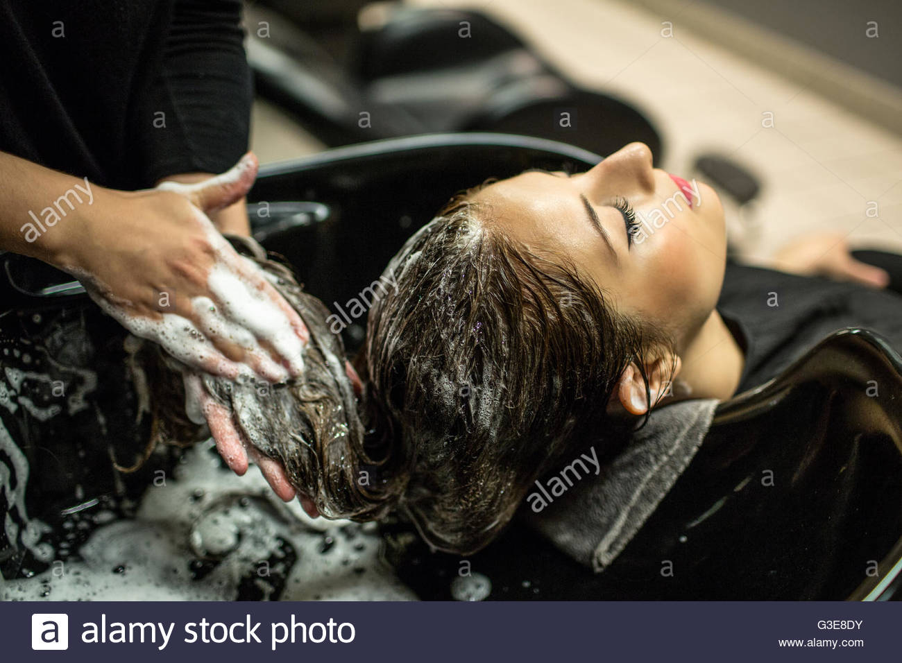 Brunette Woman With Long Hair At Shampoo Bowl At Hair Salon