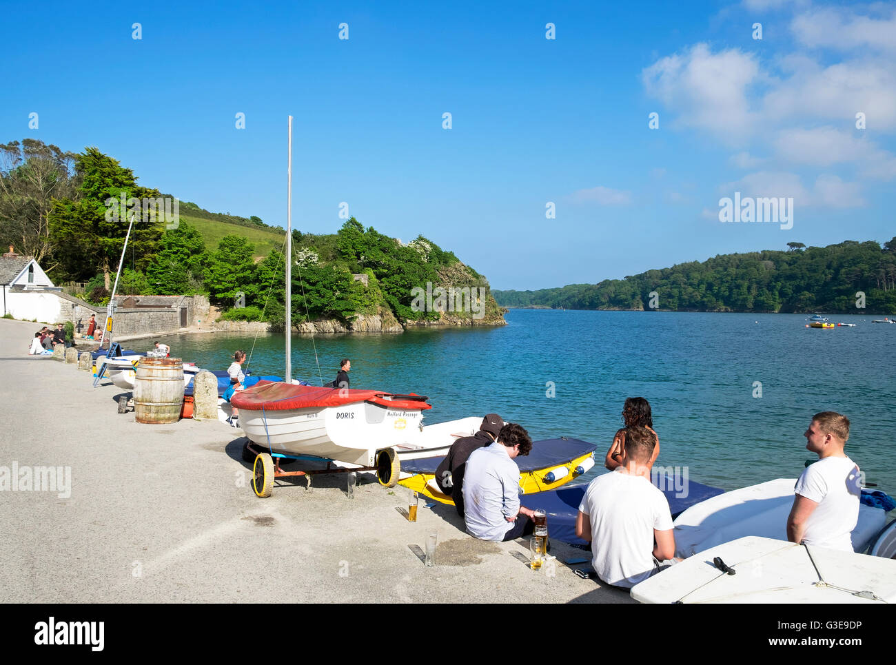 People relaxing by the river at Helford Passage in Cornwall, England, UK Stock Photo