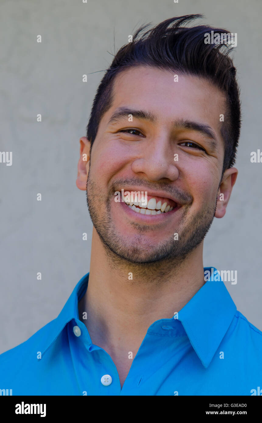 portrait of a handsome young Hispanic man smiling looking very happy ...