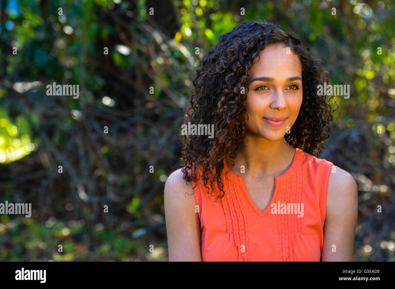 mixed race ethnic young girl sitting outside in a chair Stock Photo