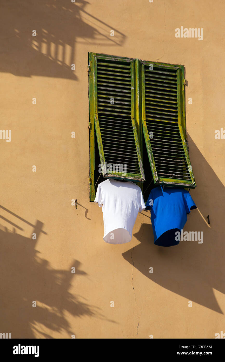 Traditional italian window with drying t-shirts in Lucca, Italy Stock Photo