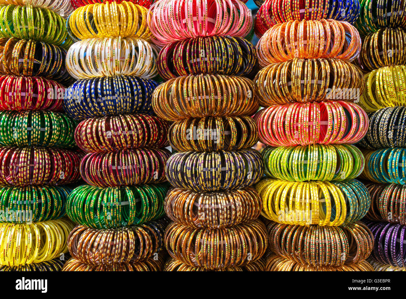 Colourful Indian wrist bracelets stacked in piles on display at a shop in Jaisalmer, India. Stock Photo