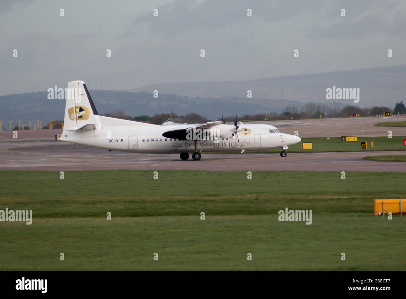 VLM Airlines Fokker 50 regional turbo-prop aircraft (OO-VLP) taxiing on Manchester International Airport tarmac. Stock Photo