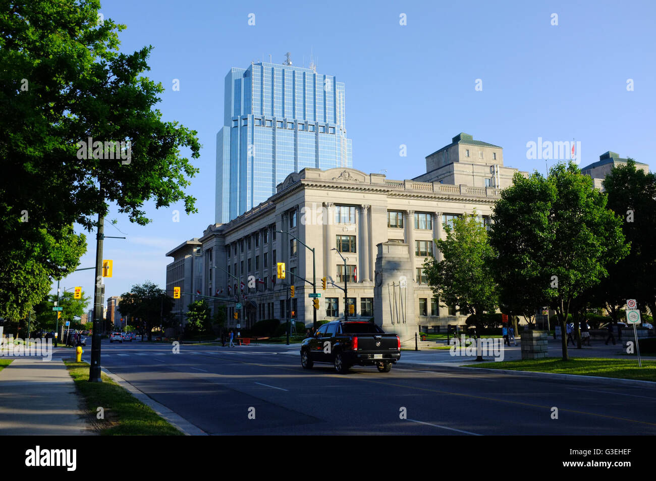 A glass skyscraper stands in front of a blue sky on downtown London, Ontario. Stock Photo