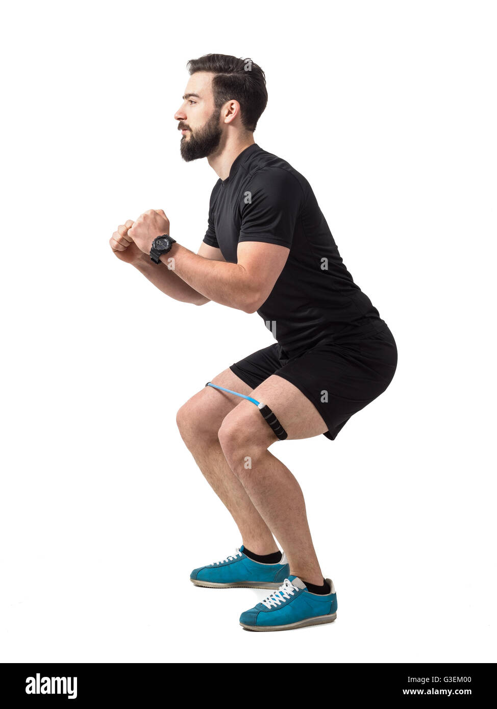 Young athlete squatting exercise with resistance band around legs