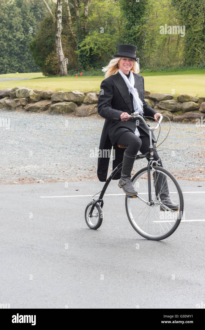 Young woman in Top Hat  riding a Penny Farthing bicycle Stock Photo