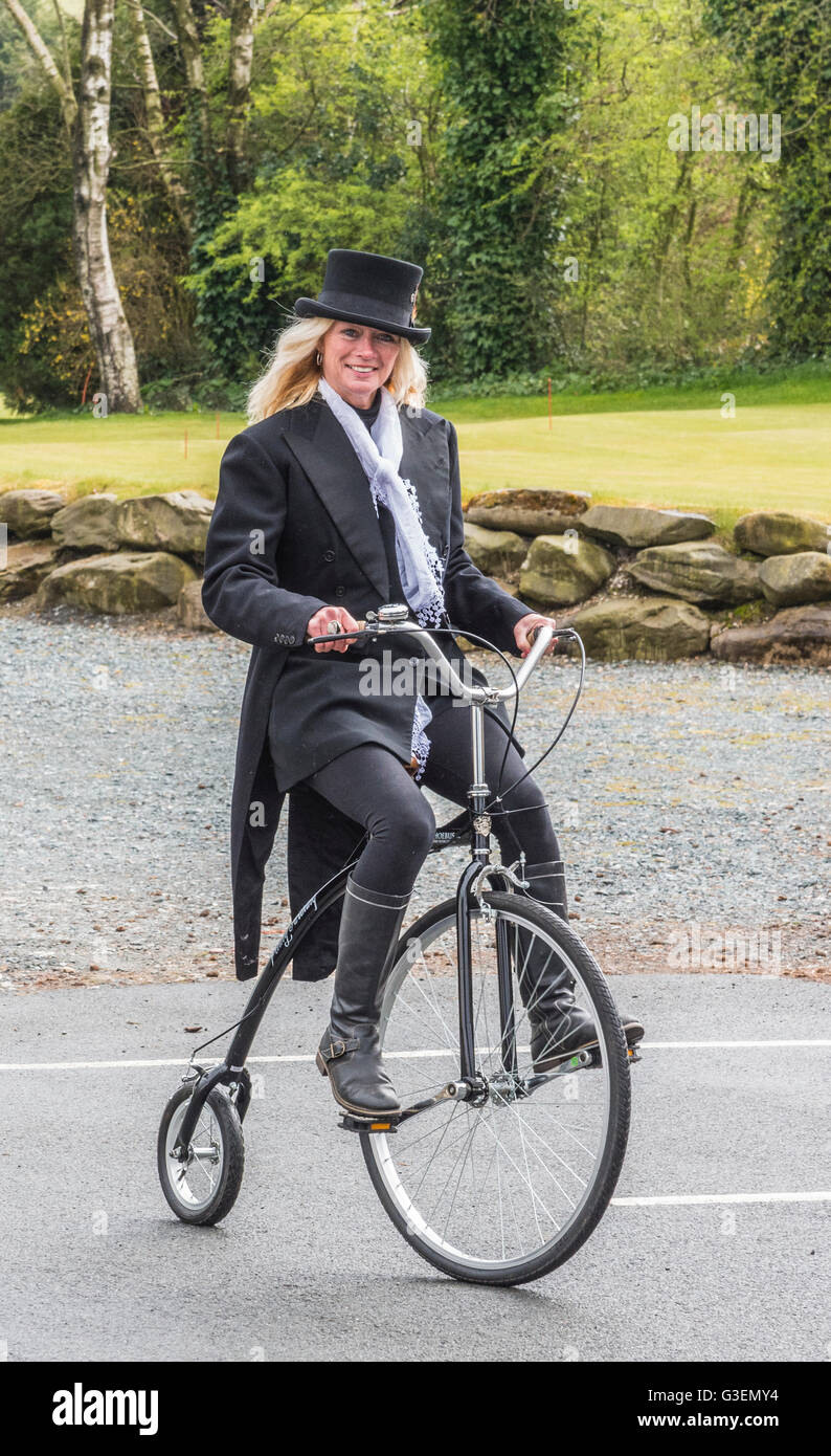 Young woman in Top Hat  riding a Penny Farthing bicycle Stock Photo