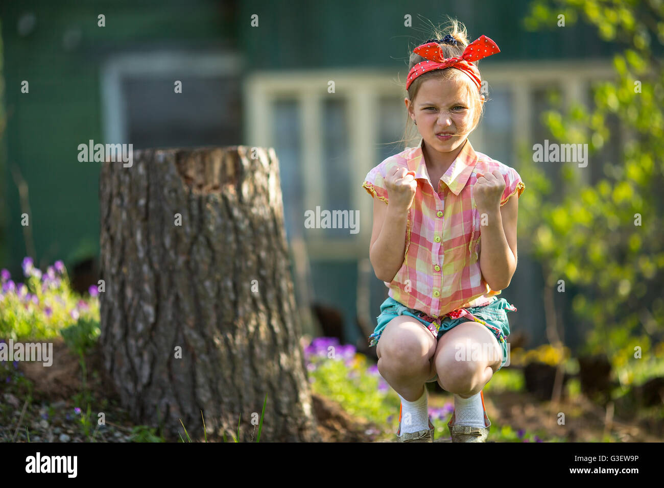 Angry little girl sitting outdoor. Stock Photo