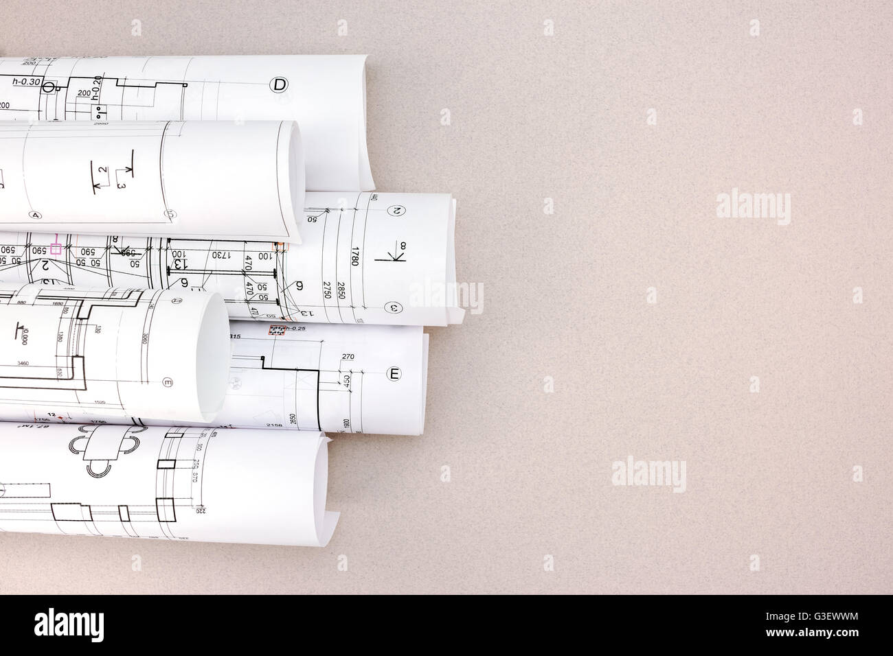 rolls of architectural blueprints and house plans on the desk top view ...