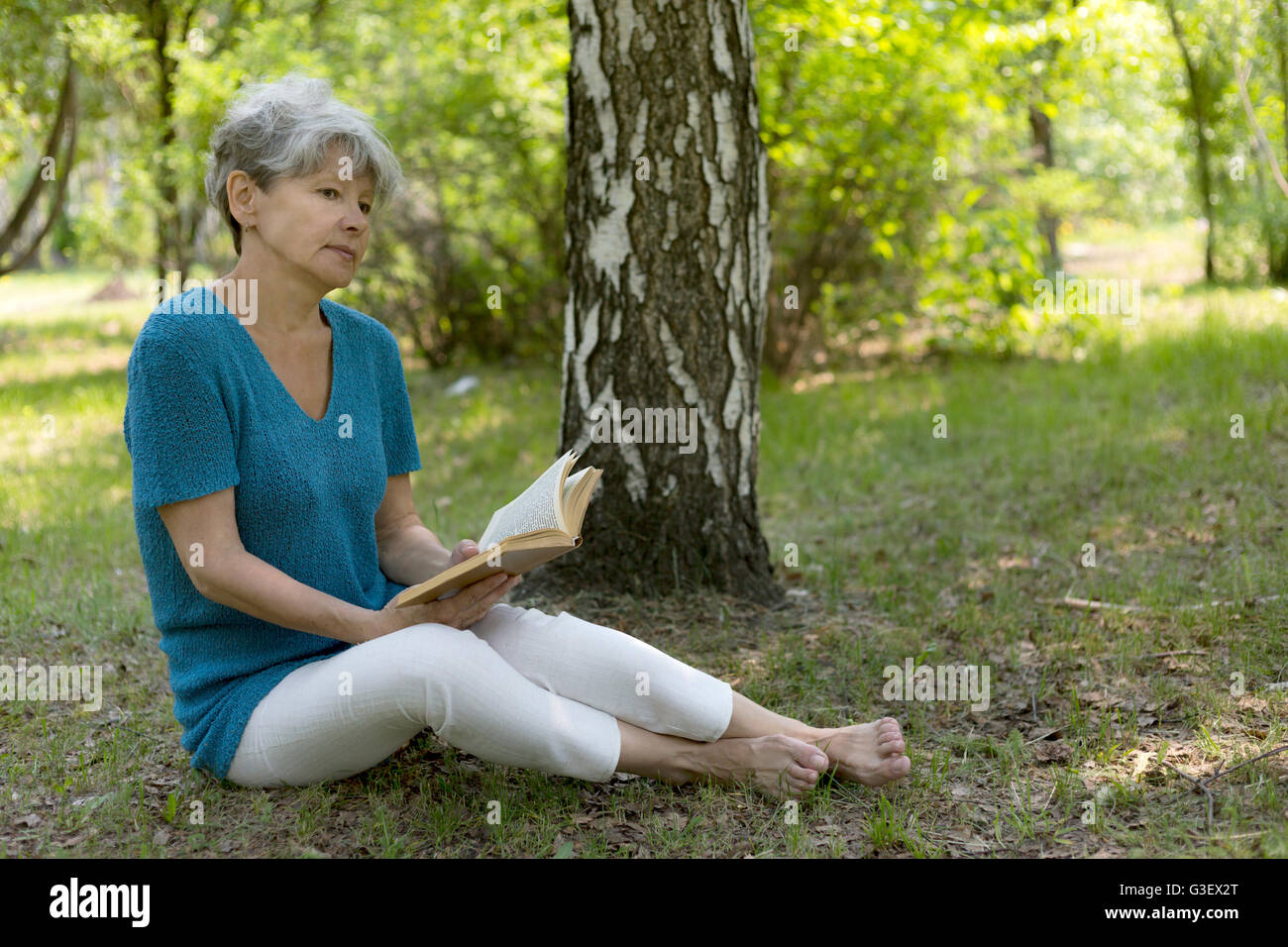 Senior woman reading a book Stock Photo - Alamy