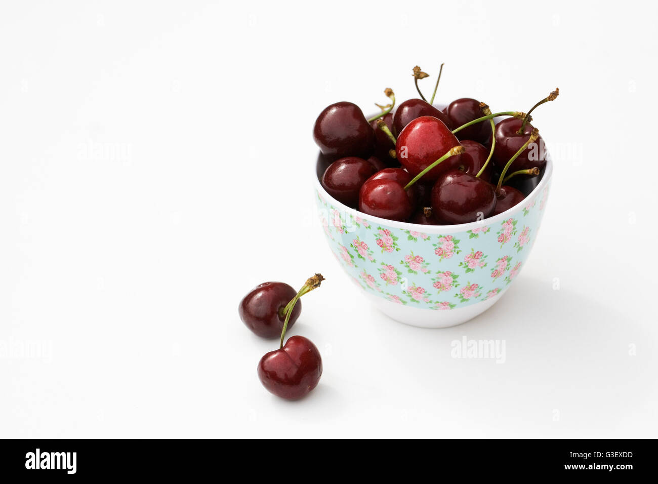 Fresh cherries in a bowl on a white background. Stock Photo