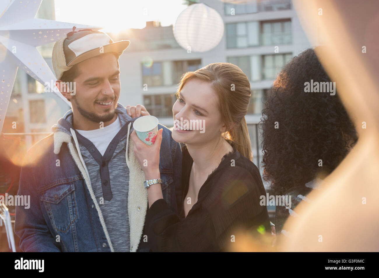Young couple drinking and enjoying rooftop party Stock Photo