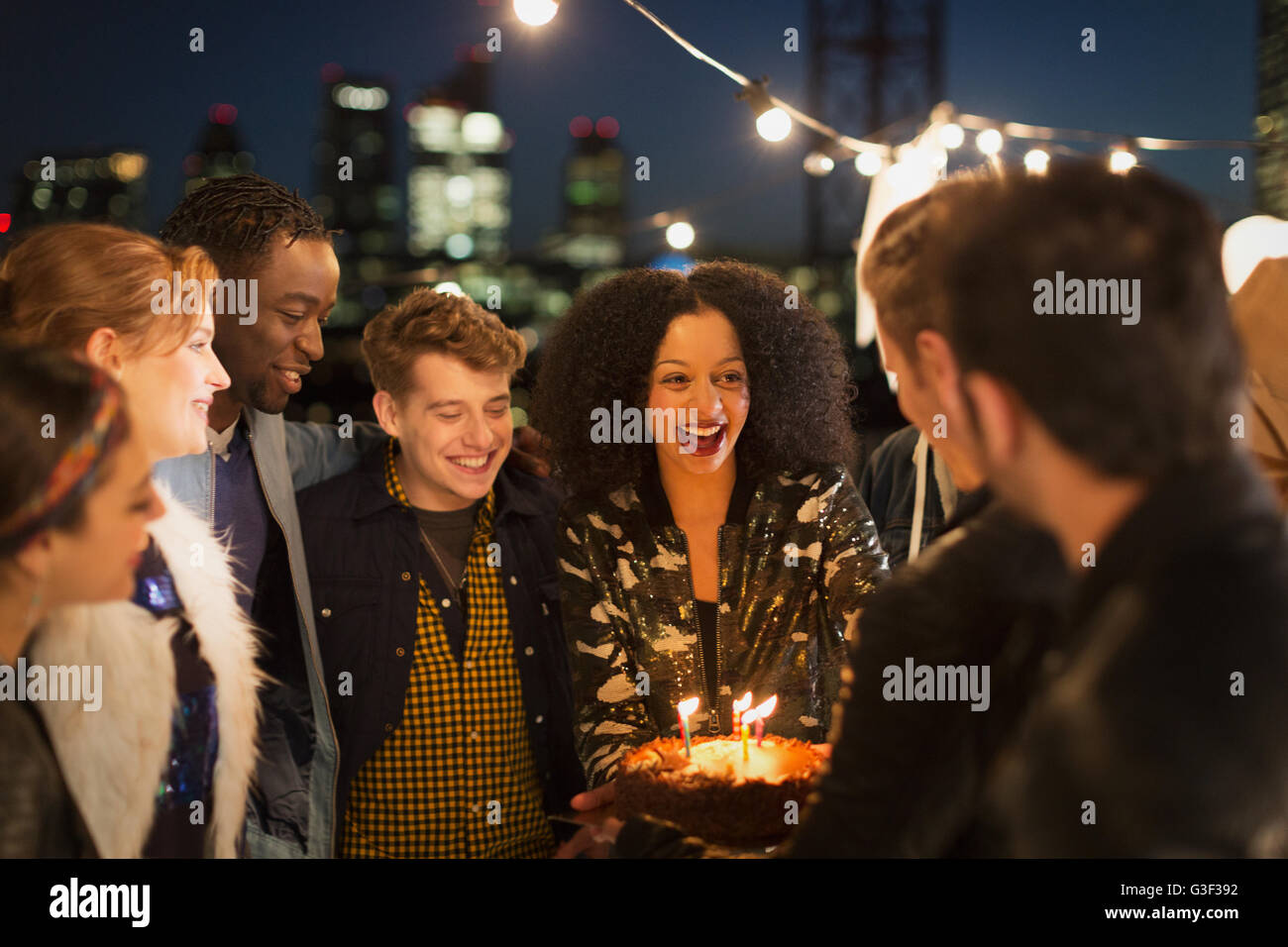 Young friends celebrating birthday at rooftop party Stock Photo