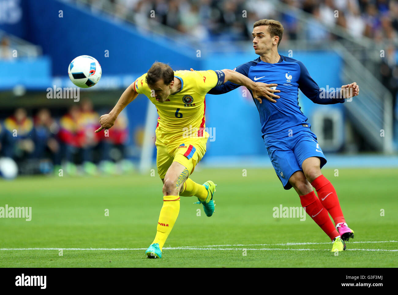 Romania's Vlad Chiriches (left) and France's Antoine Griezmann battle for the ball during the UEFA Euro 2016, Group A match at the Stade de France, Paris. Stock Photo