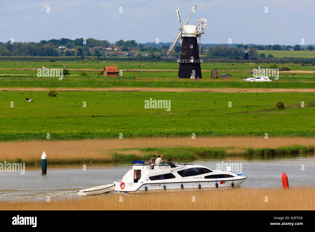 Norfolk Broads pleasure boat near Berney Arms windmill, Reedham,as seen from the roman fort at Burgh Castle, Norfolk, England Stock Photo