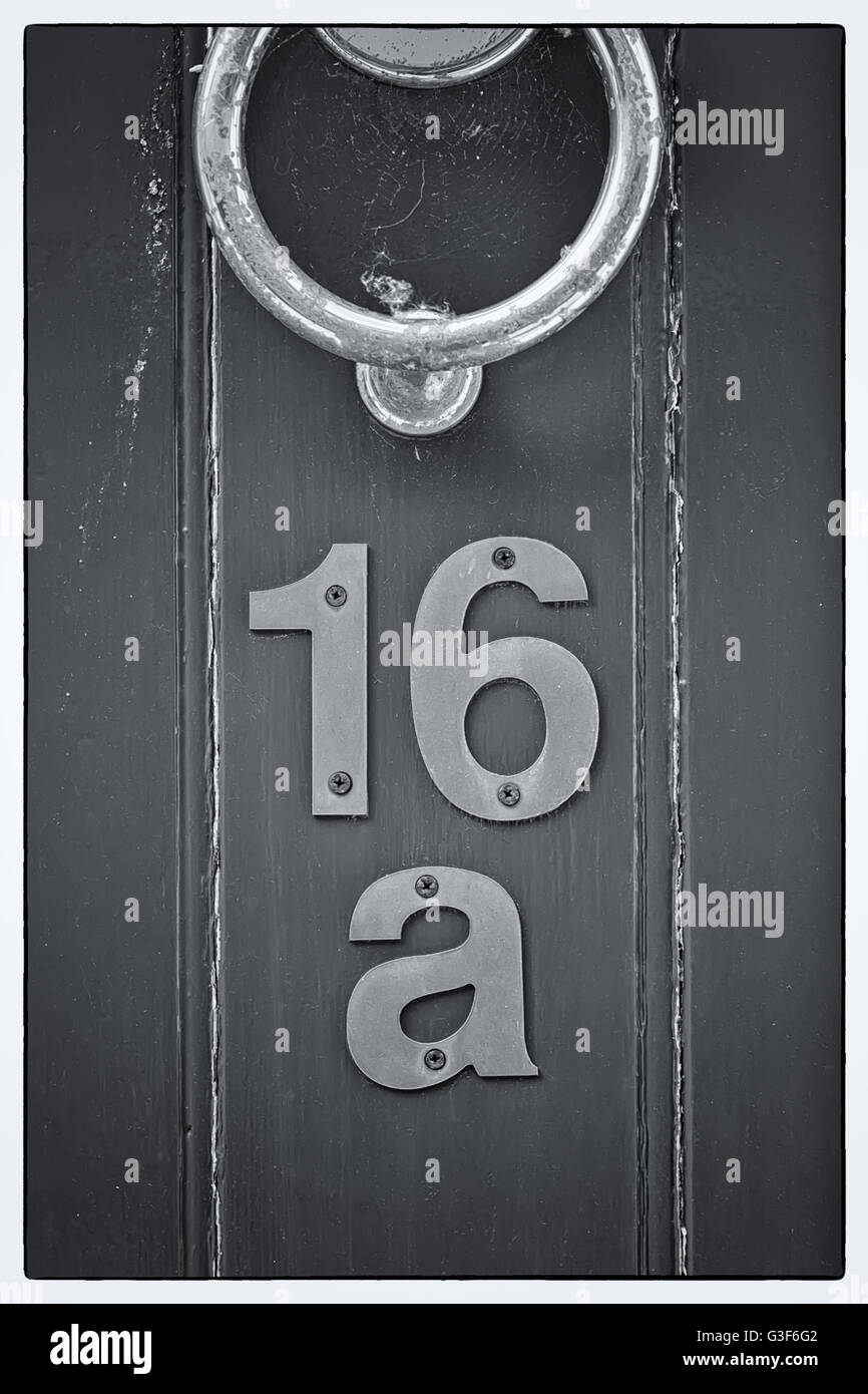 Light blue English period wooden front door with ornate iron door