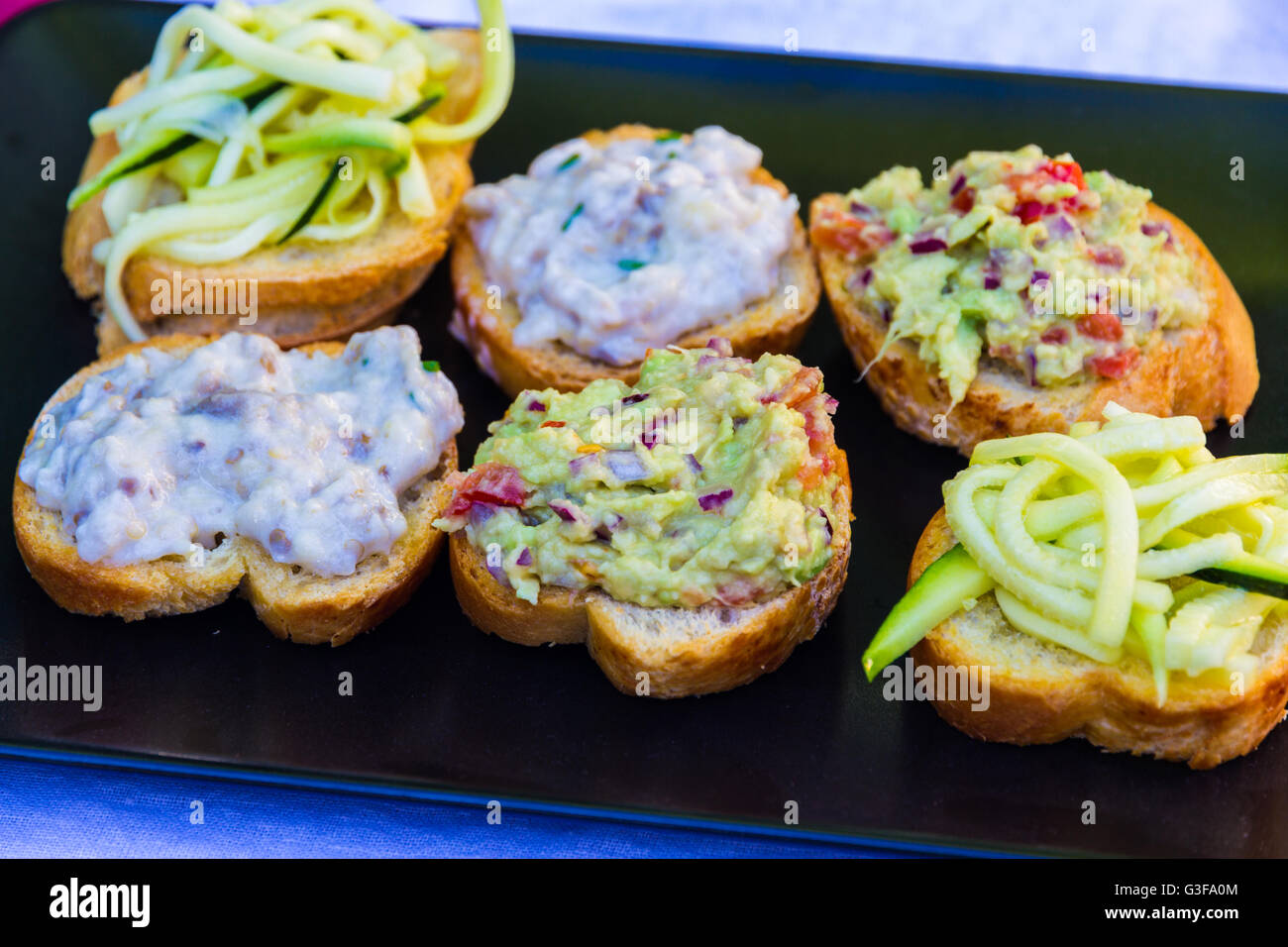 Courgette salad, guacamole and aubergine dip on bread. Cicchetti from Venice Italy, similar to bruschetta or tapas. Stock Photo