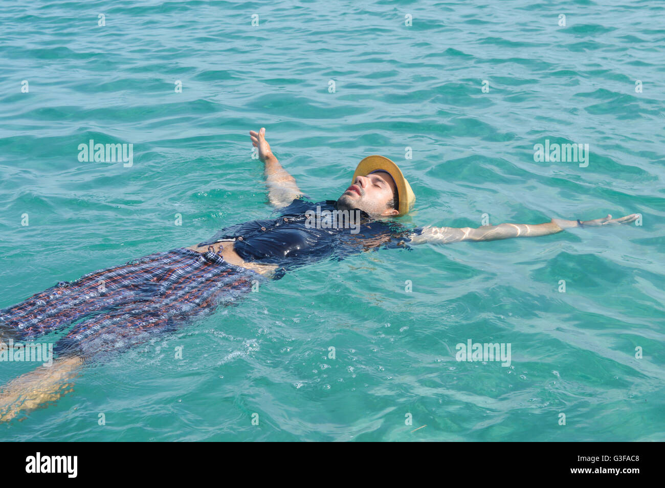Dressed up man floating on the water. Summer relaxation Stock Photo
