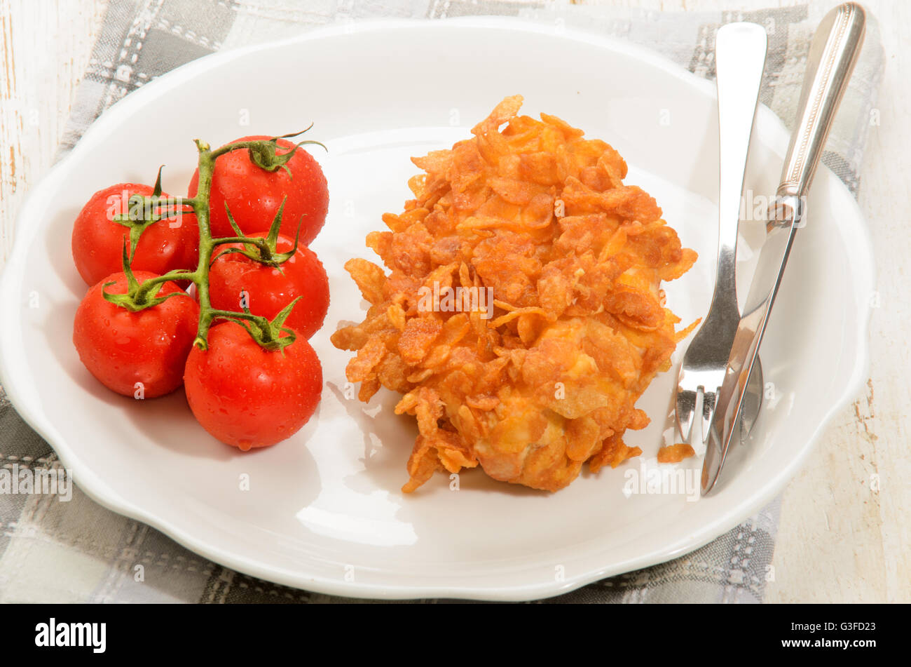 deep fried chicken fillet coated with corn flakes and wet tomato on a plate Stock Photo Alamy