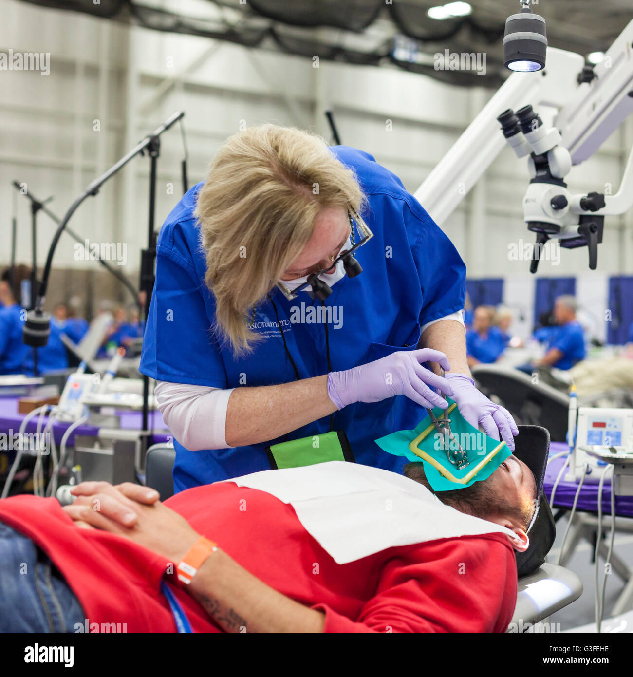 Warren, Michigan, USA. 10th June, 2016. A dentist performs a root canal procedure for a patient, one of several thousand people who received free dental care from volunteer dental professionals at a two-day clinic organized by the nonprofit Mission of Mercy. Credit:  Jim West/Alamy Live News Stock Photo