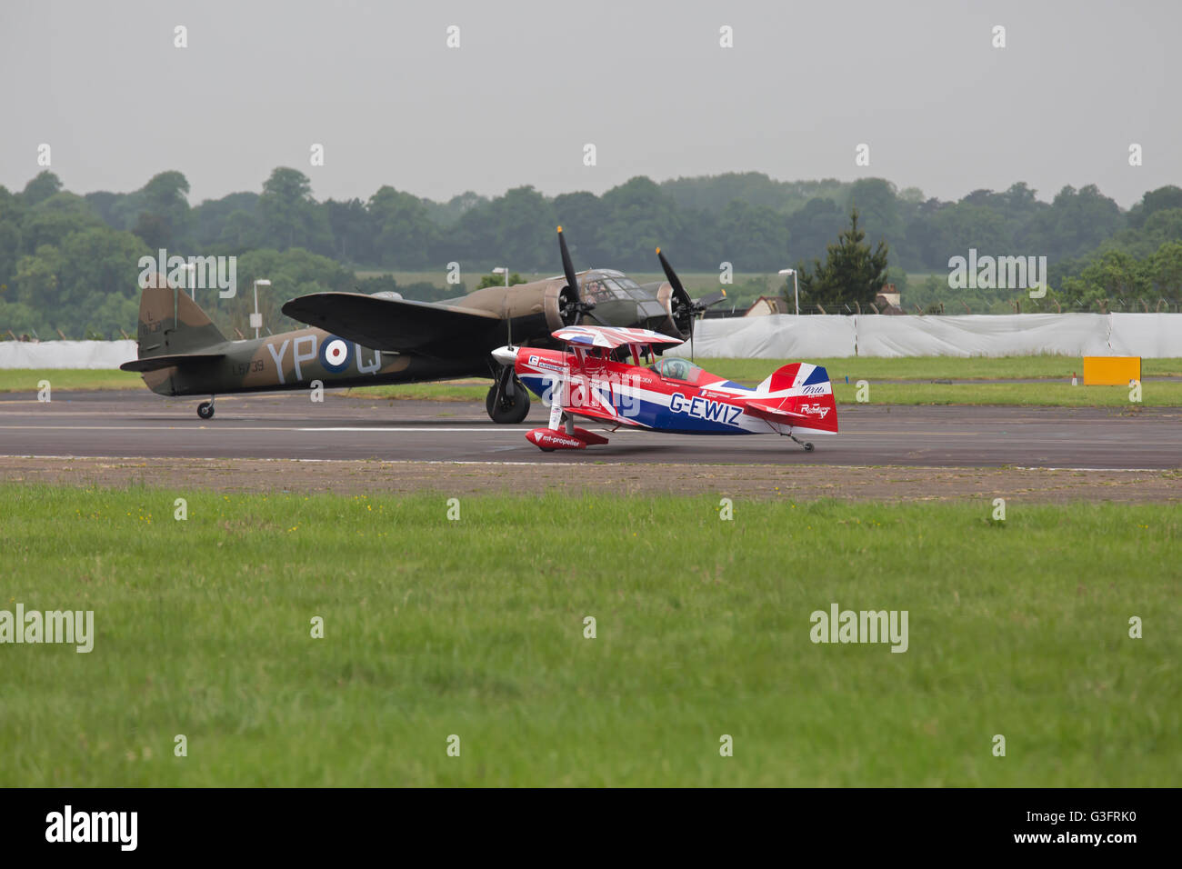 Biggin Hill, UK. 11th June 2016. Pitts S2S passes the Bristol Blenheim G-BPIV on the runway at the Biggin Hill Festival of Fligh Credit: Keith Larby/Alamy Live News Stock Photo