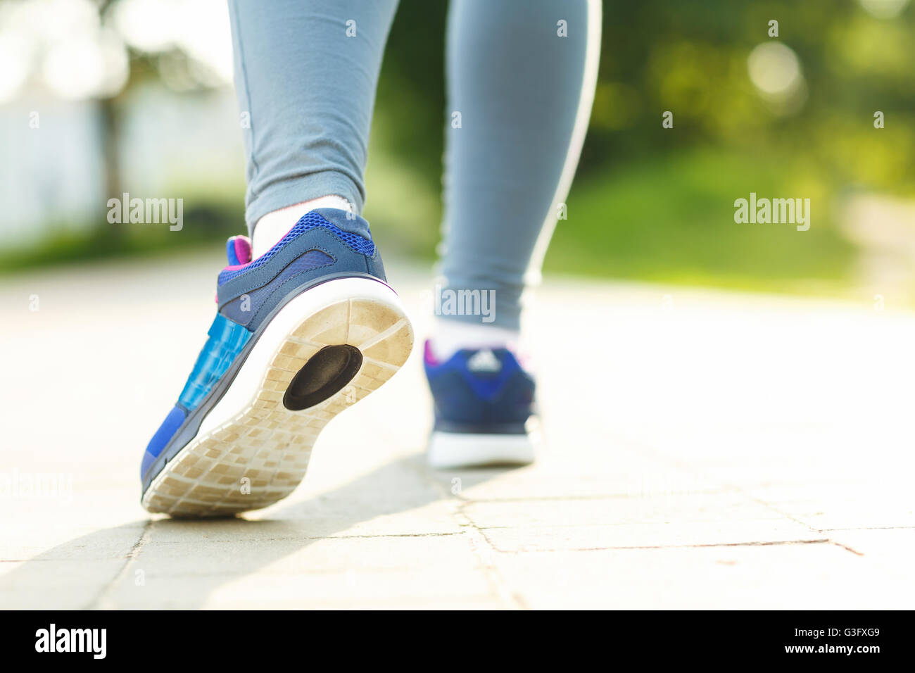 Running shoes - closeup of female sport fitness runner getting ready for jogging outdoors in summer Stock Photo