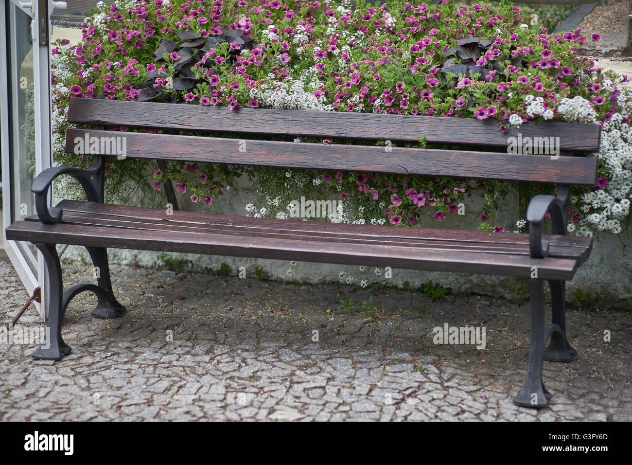 Park bench surrounded by blooming flowers Stock Photo