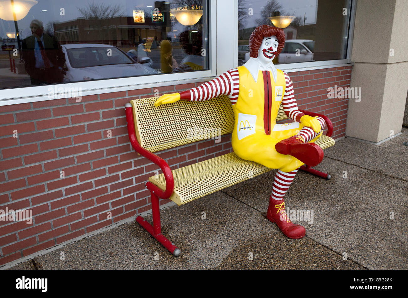 Ronald McDonald clown statue sitting on fast-food restaurant's bench. Redwood Falls Minnesota MN USA Stock Photo