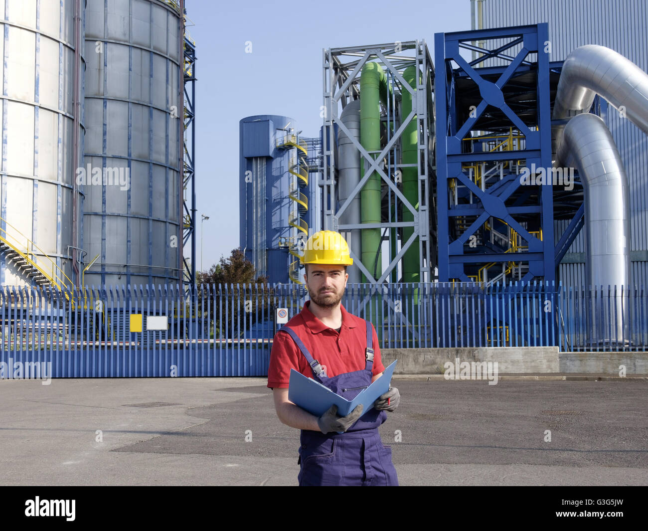 laborer outside a factory working dressed with safety overalls equipment Stock Photo