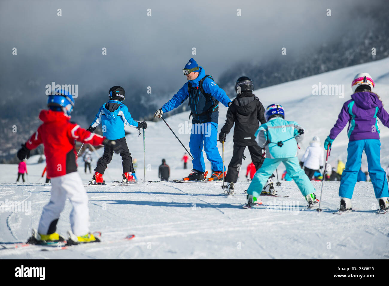 A ski instructor teaches a group of children in the French ski resort of Courchevel. Stock Photo