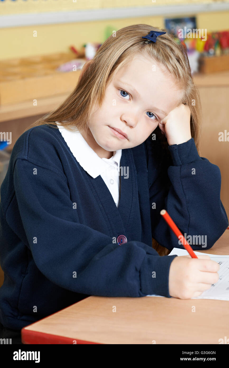 Bored Female Elementary School Pupil At Desk Stock Photo - Alamy