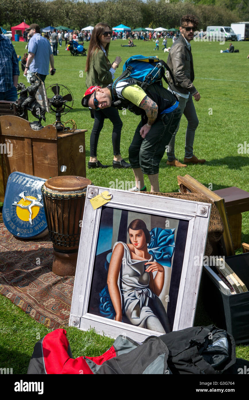 Visitors checking out the artwork and bric-a-brac for sale on a stall during the Meadows Festival in Edinburgh. Stock Photo