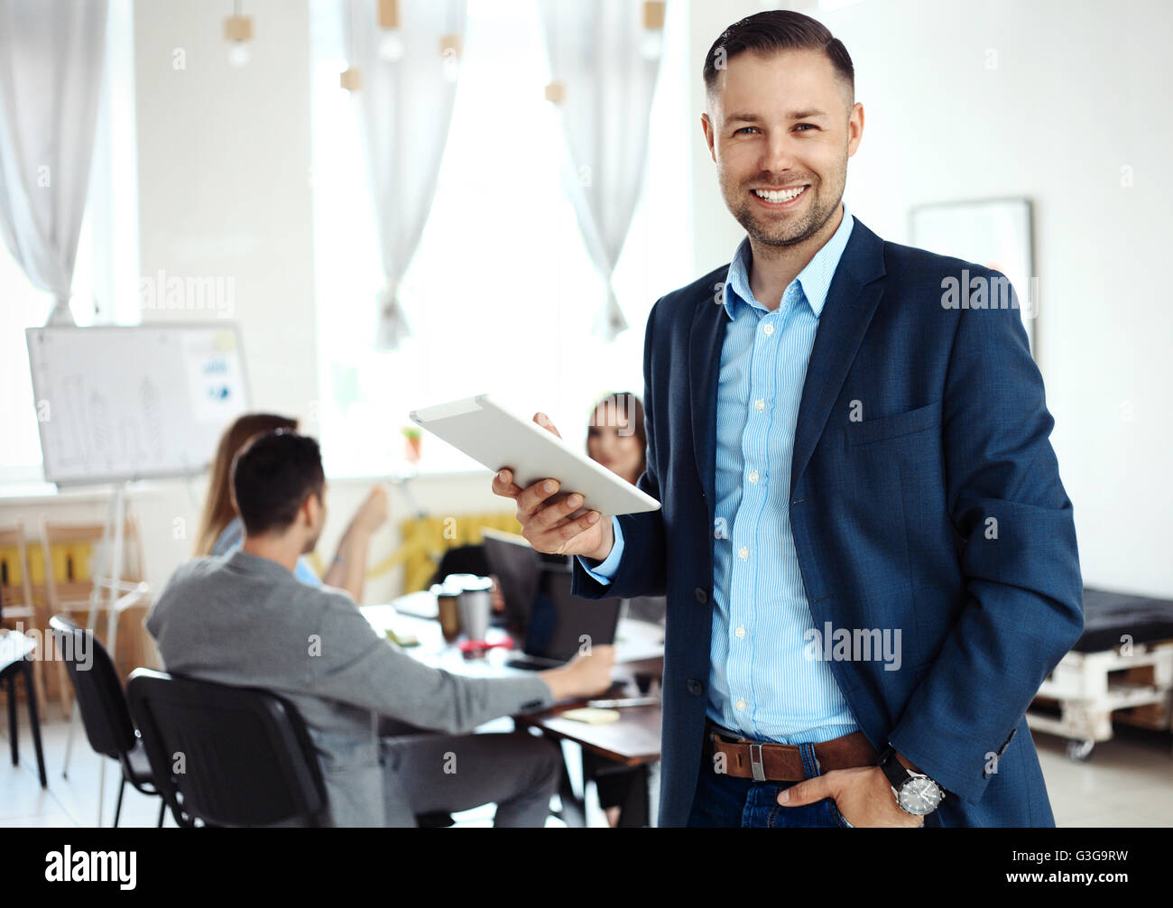 Businessman using his tablet in office Stock Photo - Alamy