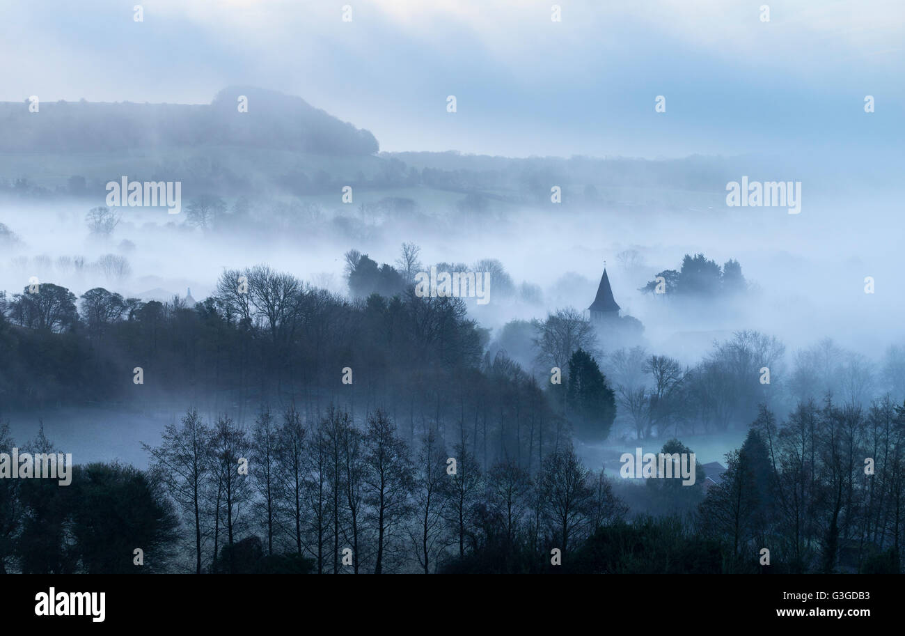 Early morning mist on the North Kent Downs overlooking the village of Postling near Hythe. Stock Photo
