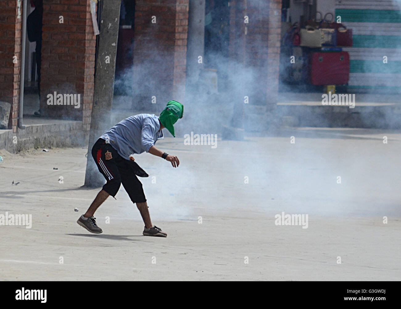 Old Srinagar, India. 03rd June, 2016. A Kashmiri Muslim protester throw stones during anti India demonstration in old Srinagar. The policemen used tear gas to the protesters. Earlier the separatists leadership had called for post Friday prayers protest against the establishment of proposed Sainik and Pandit colonies by government. © Faisal Khan/Pacific Press/Alamy Live News Stock Photo