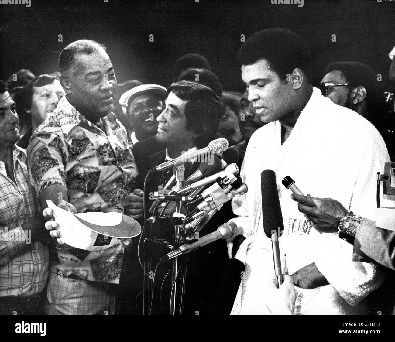 May 15, 1977 - Landover, Maryland, United States of America - Legendary former Heavyweight Champion Joe Lewis looks on as current Heavyweight Champion Muhammad Ali speaks to reporters at the weigh-in ceremony prior to the fifteen round heavyweight title fight against challenger Alfredo Evangelista of Spain at the Capitol Centre in Landover, Maryland on May 15, 1977.  Ali tipped the scales at 221 1/2 pounds.  Ali's purse will be $2.7 million and Evangelista will receive $85,000..Credit: Arnie Sachs / CNP (Credit Image: © Arnie Sachs/CNP via ZUMA Wire) Stock Photo