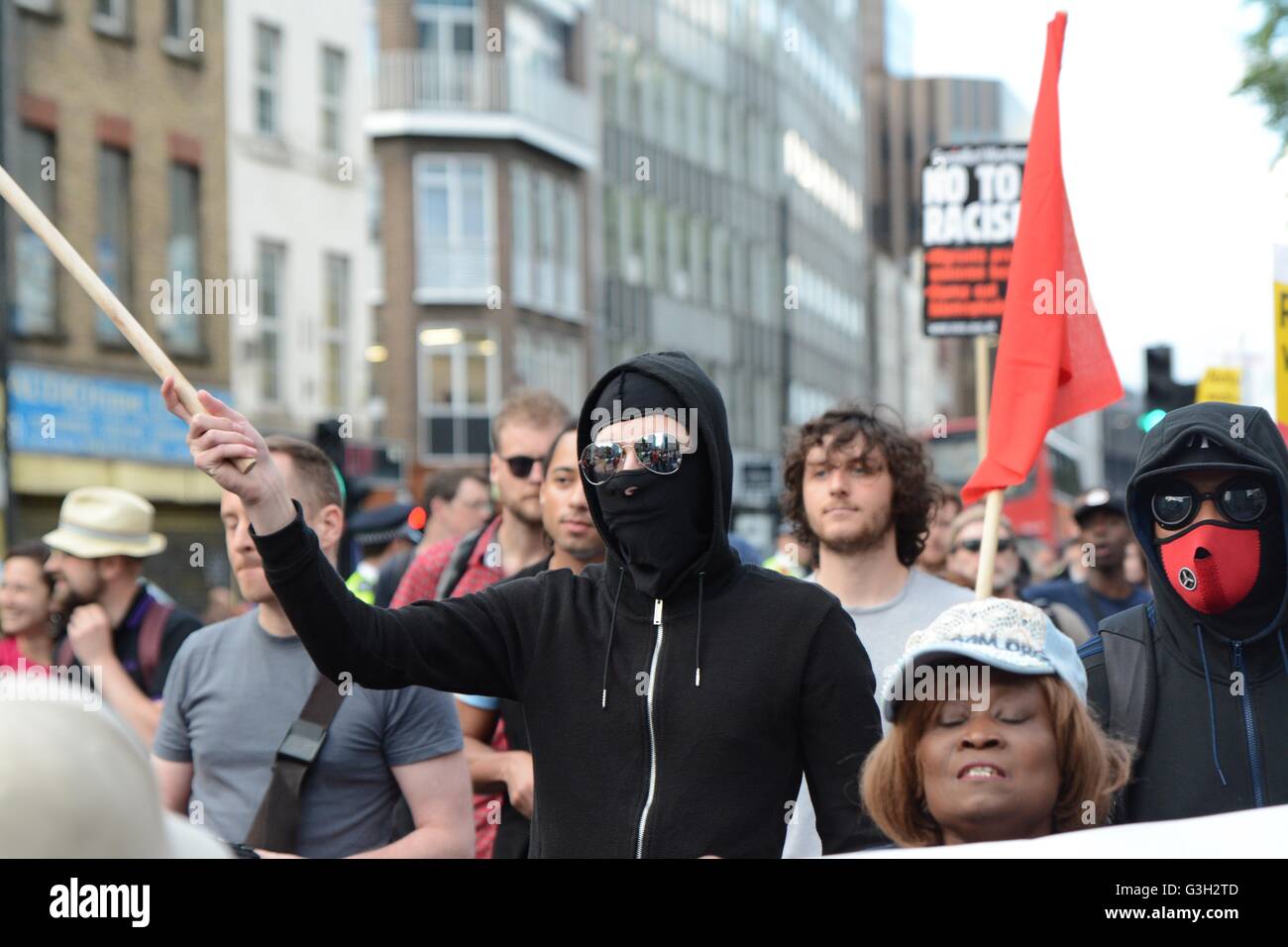 London, UK. 24 June, 2016. Pro-europe and migrant rally held in London.  Masked protesters were marching down the street with their anti-government flags. Credit:  Marc Ward/Alamy Live News Stock Photo