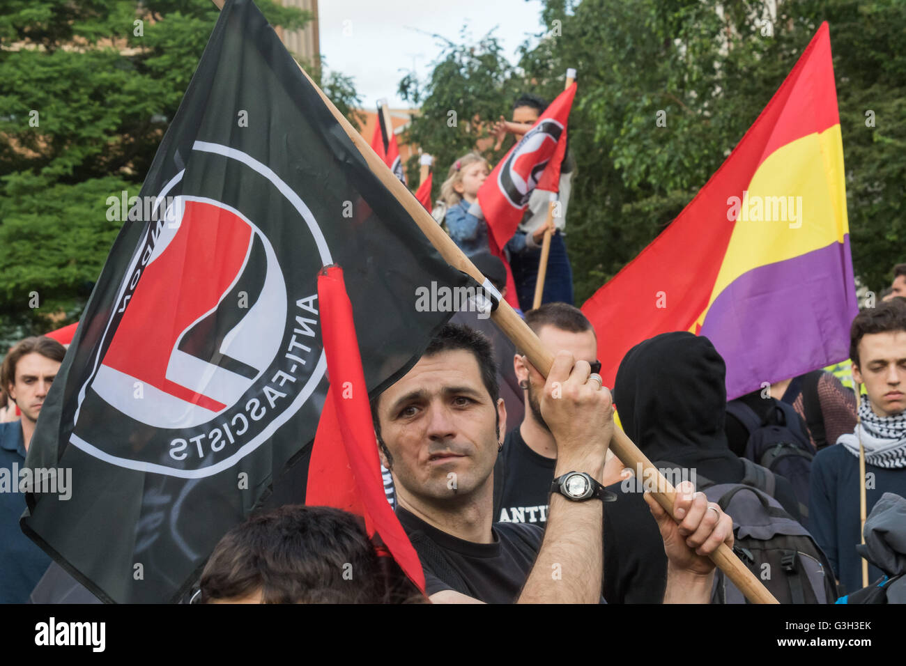 London, UK. June 24th 2016. Anti-fascist protesters with flags at the rally in Altab Ali Park on the day after the UK voted to leave the EU against racism, for migrant rights and against fascist violence. They say that migration and immigrants have been attacked and scapegoated not only by both Remain and Leave campaigns but by mainstream parties and media over more than 20 years, stoking up hatred by insisting immigrants are a 'problem'.Peter Marshall/Alamy Live News Stock Photo