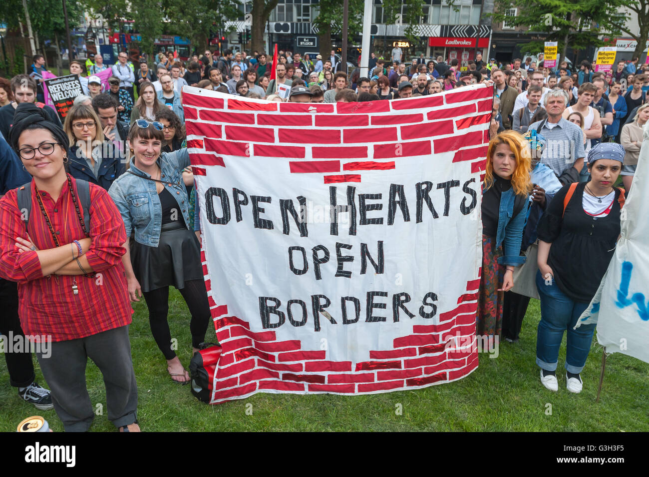 London, UK. June 24th 2016. Women hold a banner 'Open Hearts Open Borders' at the front of the crowd at the rally in Altab Ali Park on the day after the UK voted to leave the EU against racism, for migrant rights and against fascist violence. They say that migration and immigrants have been attacked and scapegoated not only by both Remain and Leave campaigns but by mainstream parties and media over more than 20 years, stoking up hatred by insisting immigrants are a 'problem'.Peter Marshall/Alamy Live News Stock Photo